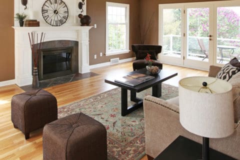 A living room with brown walls and wooden floors.