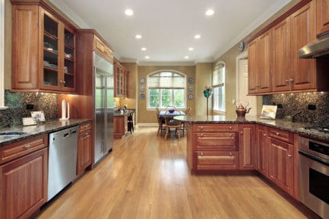 A kitchen with wood floors and stainless steel appliances.
