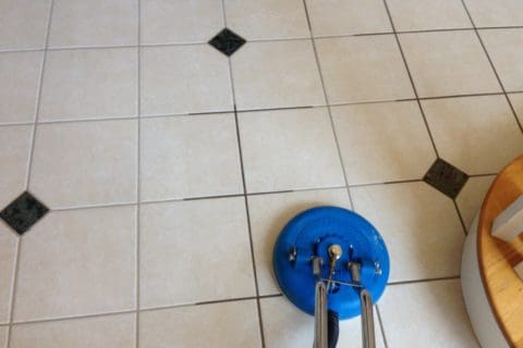 A tile floor being cleaned with a blue machine.