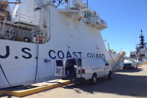 A white coast guard boat parked in the dock.